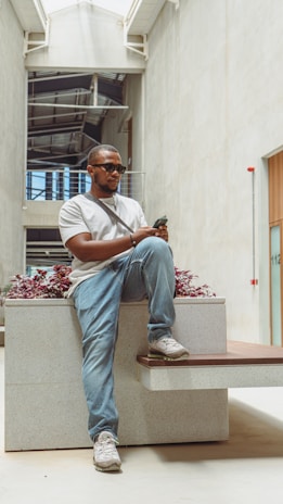 a man sitting on a bench holding a cell phone
