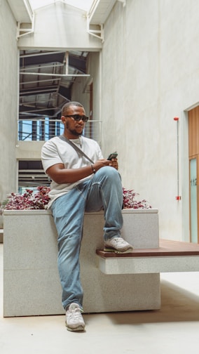 a man sitting on a bench holding a cell phone