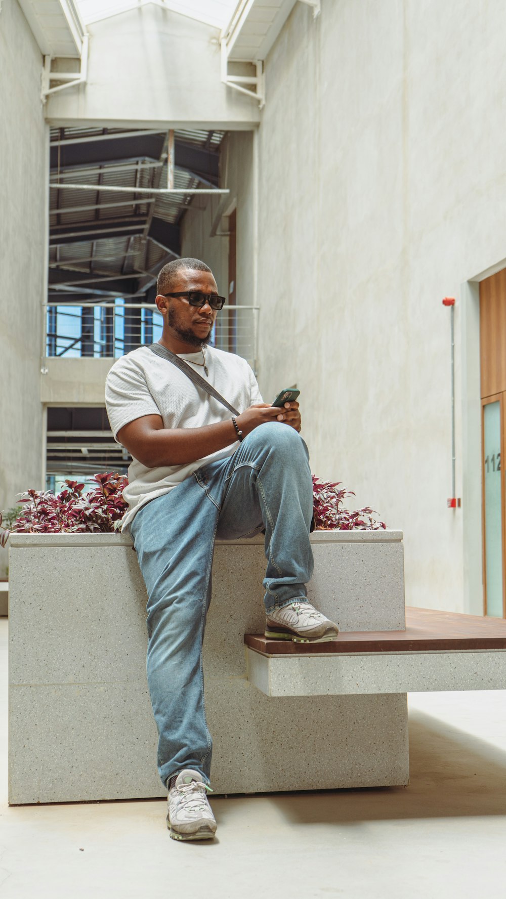 a man sitting on a bench holding a cell phone