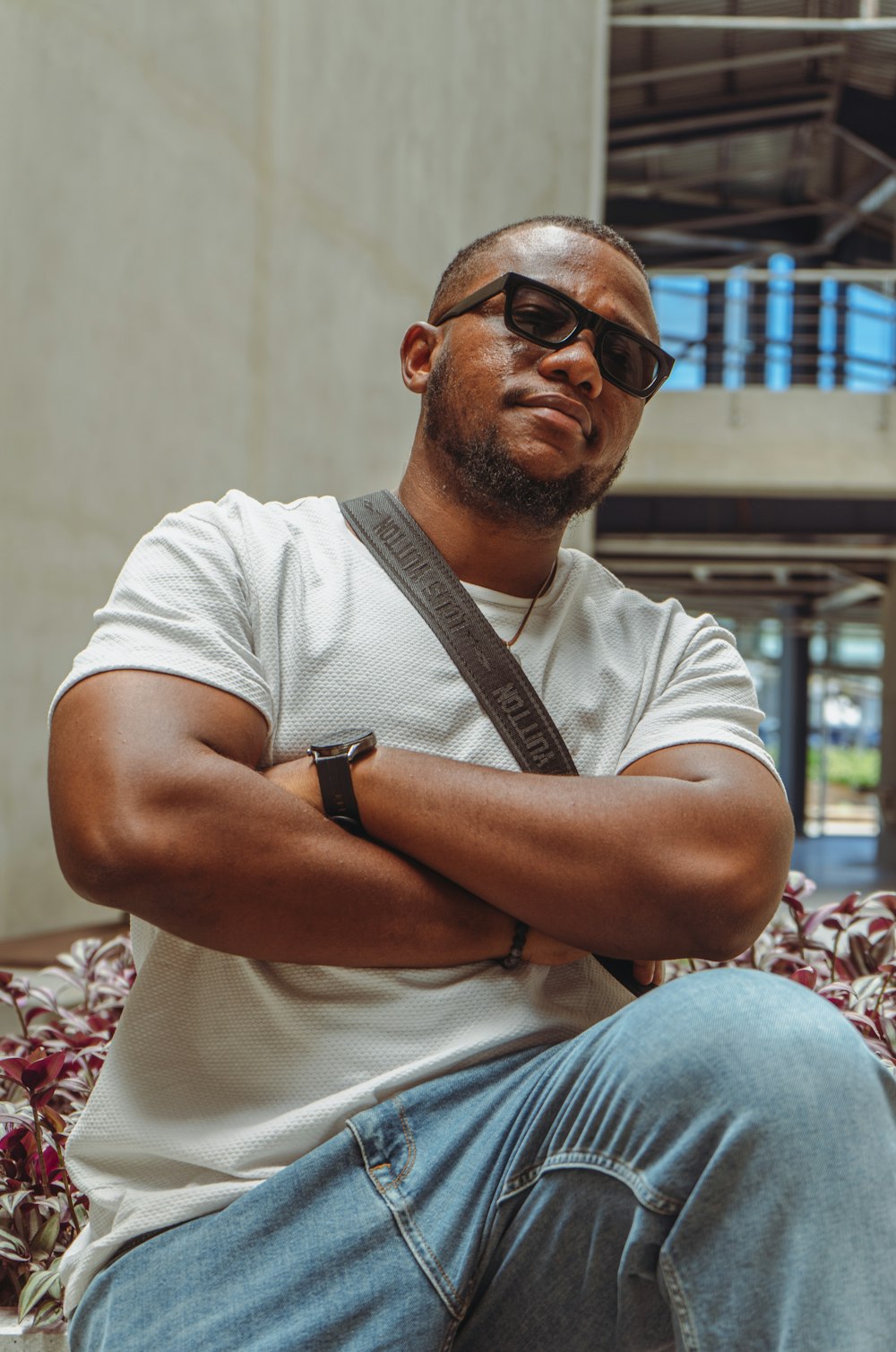 a man sitting on a bench with his arms crossed