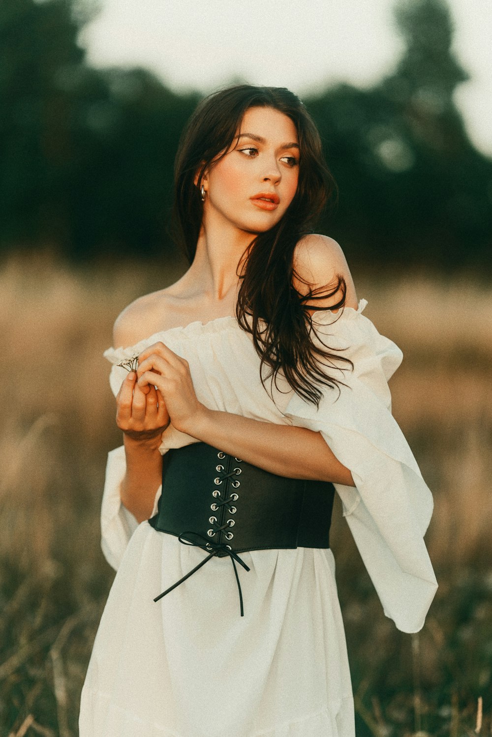 a woman wearing a corset in a field