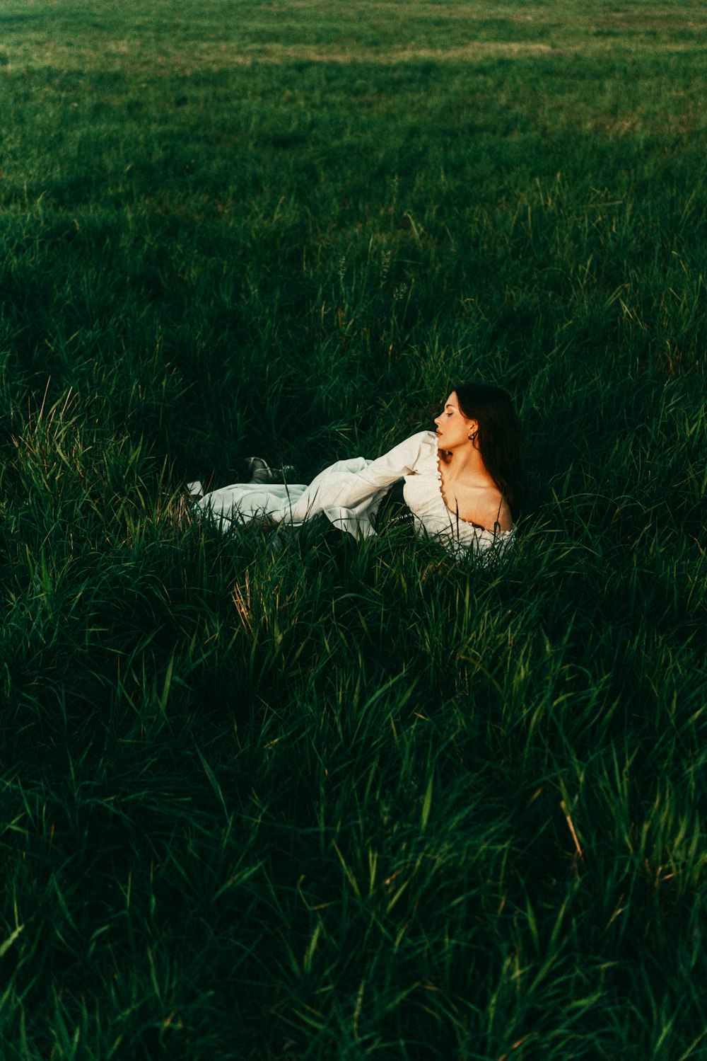 a woman laying in a field of green grass