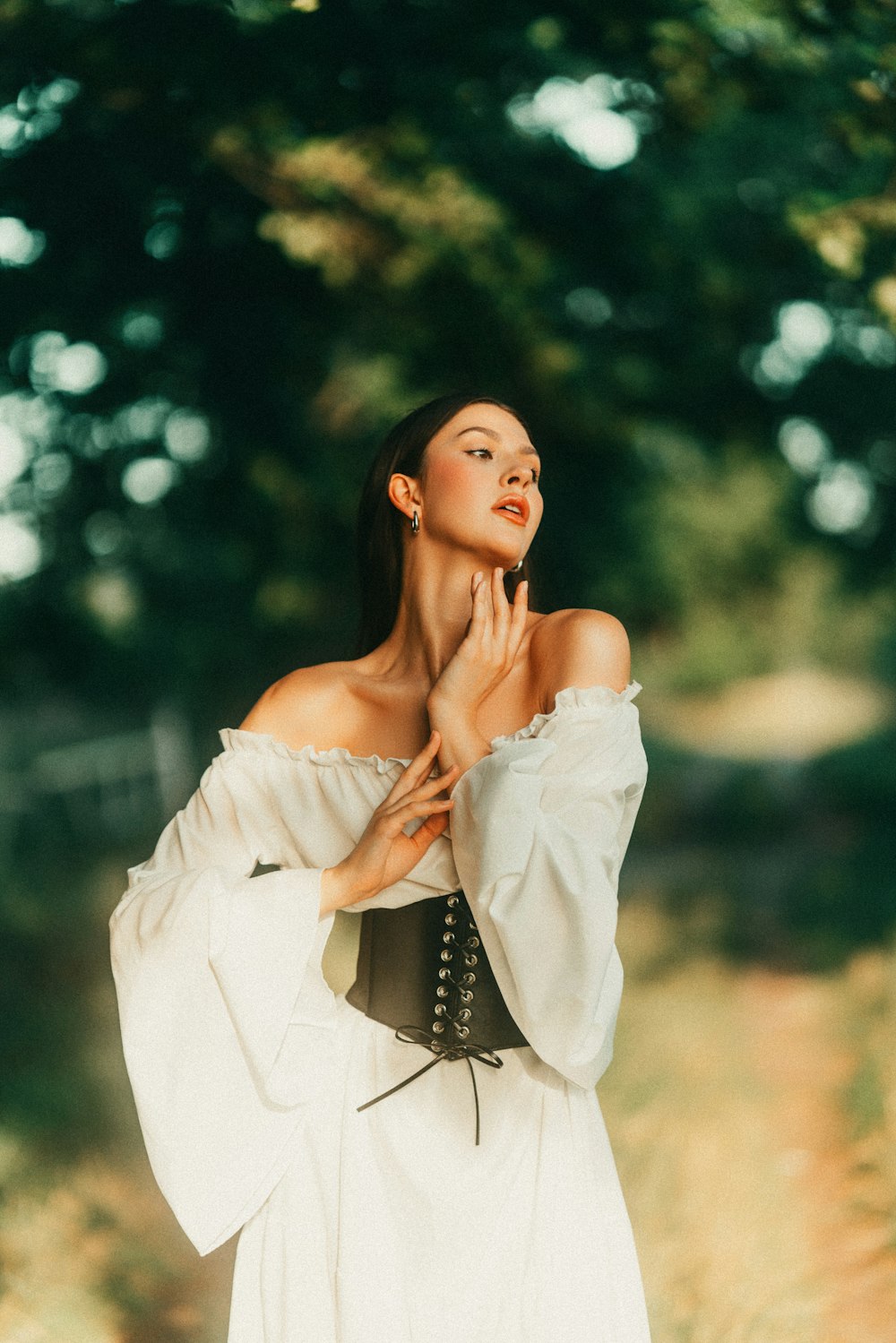 a woman in a white dress standing in a field