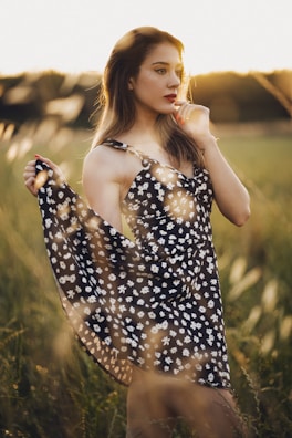 Sunlit outdoor shot of a model wearing a flowing midi dress with soft floral patterns.