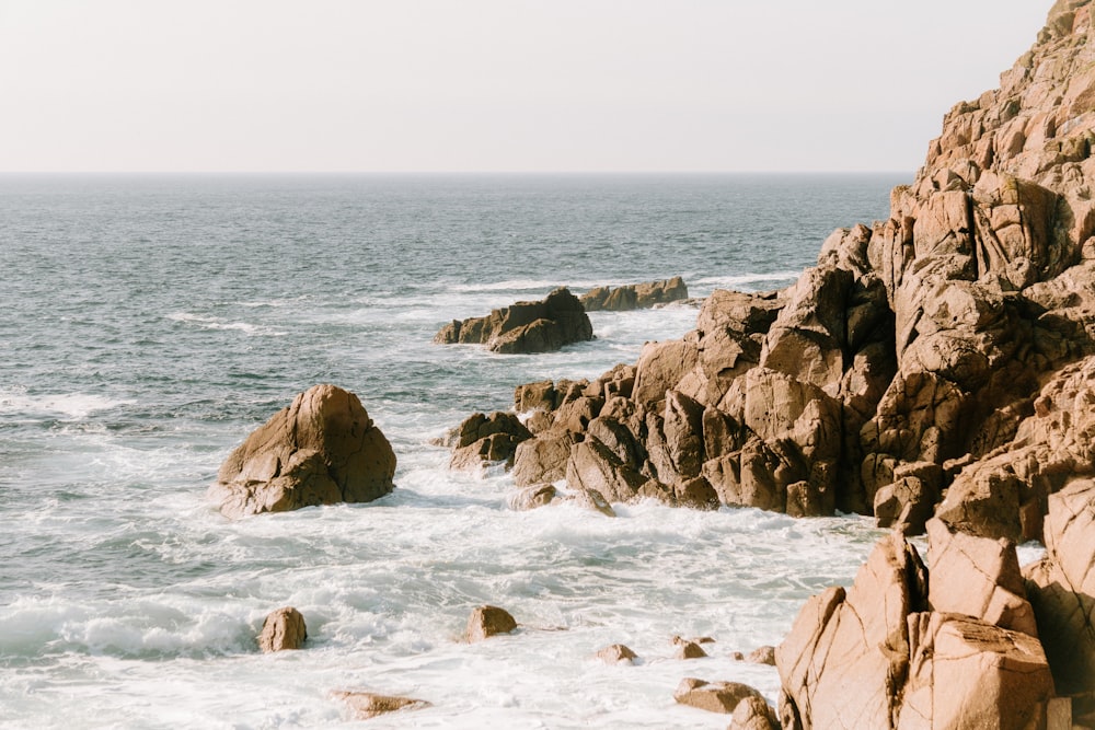Una costa rocciosa con onde che si infrangono contro le rocce