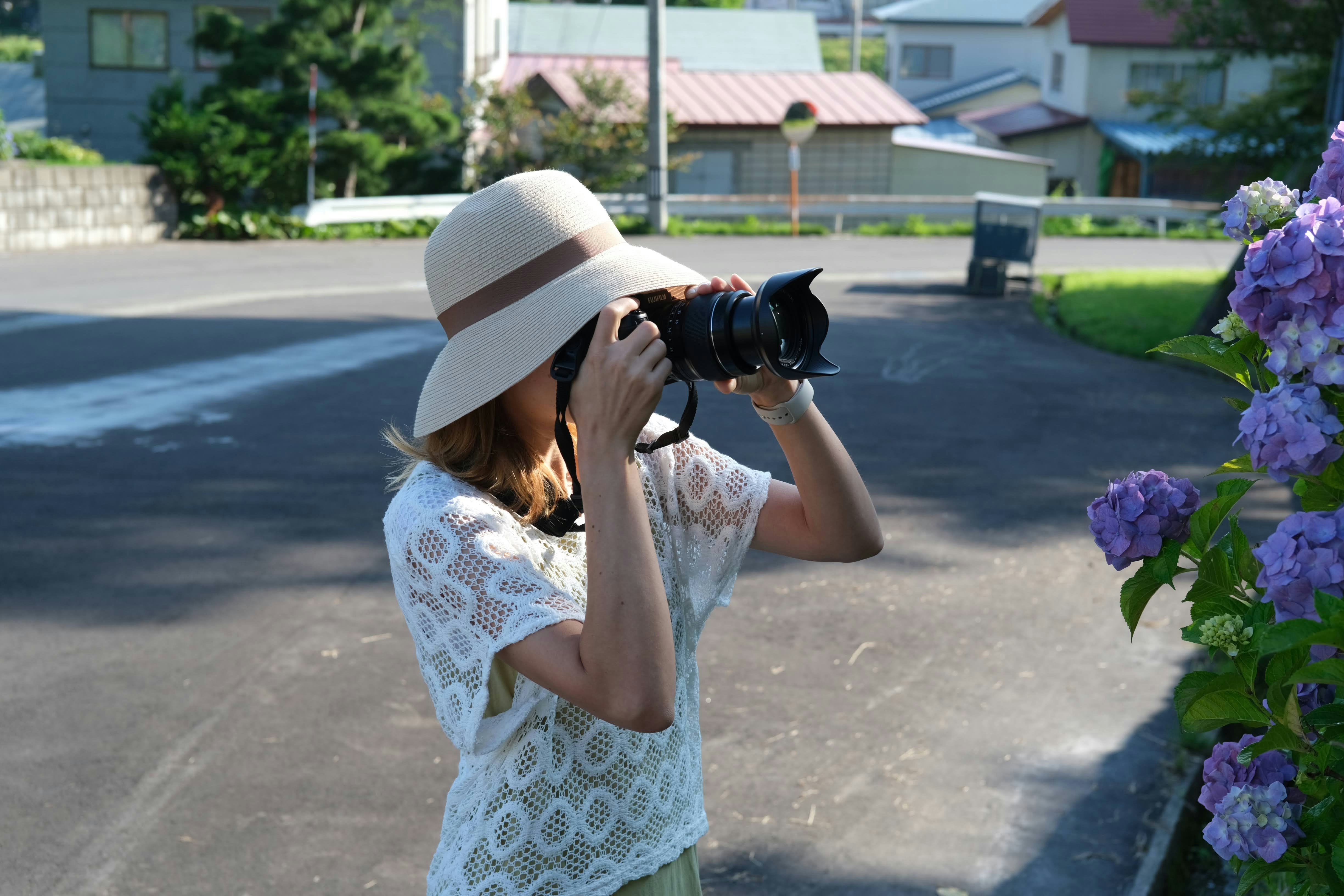 a woman taking a picture of a cat with a camera
