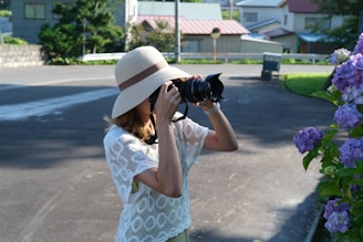 a woman taking a picture of a cat with a camera