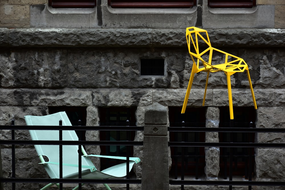 시멘트 벽 위에 앉아 ��있는 노란 의자