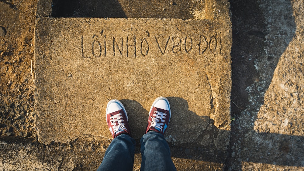 a person standing on a sidewalk with their feet up