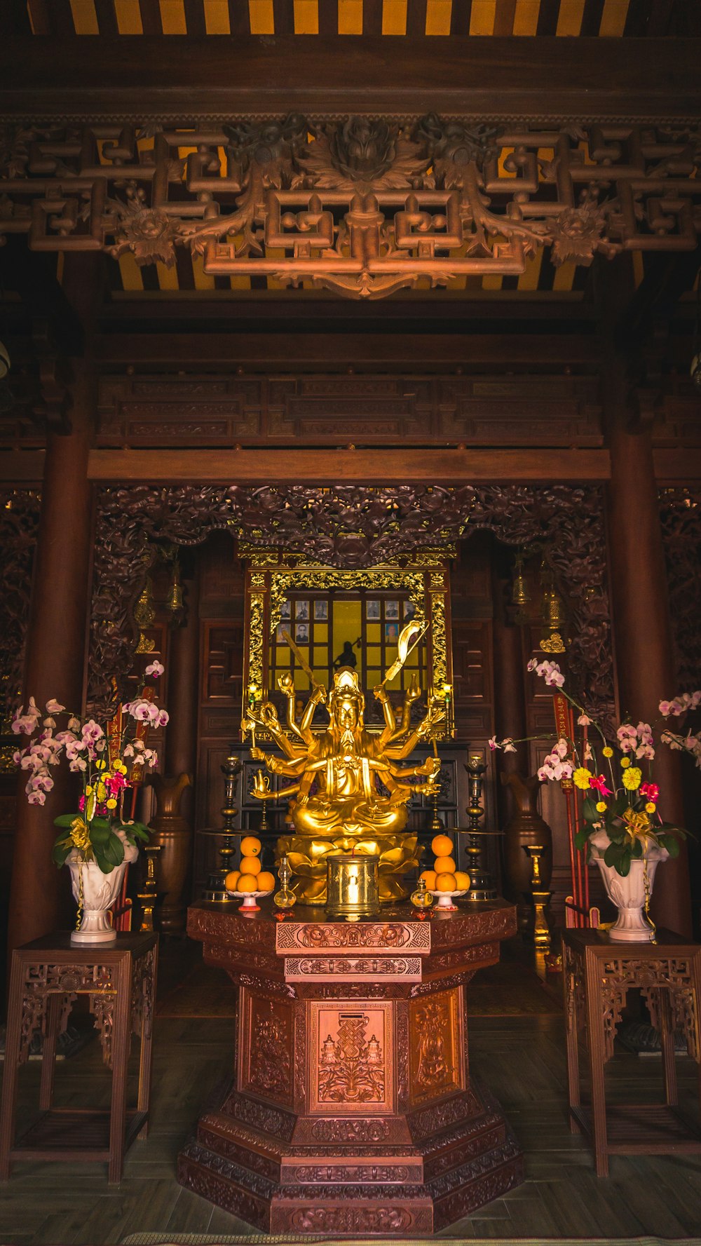 a golden buddha statue sitting in front of a wooden table