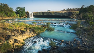a river with a waterfall in the background