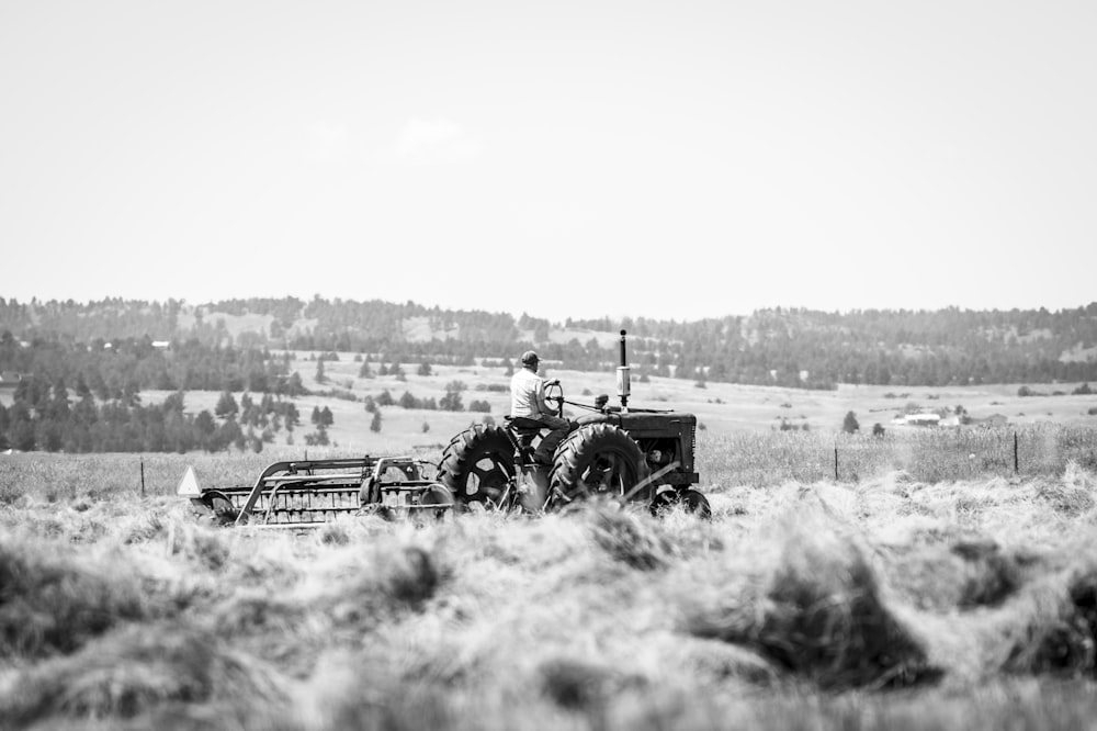 a black and white photo of a man on a tractor