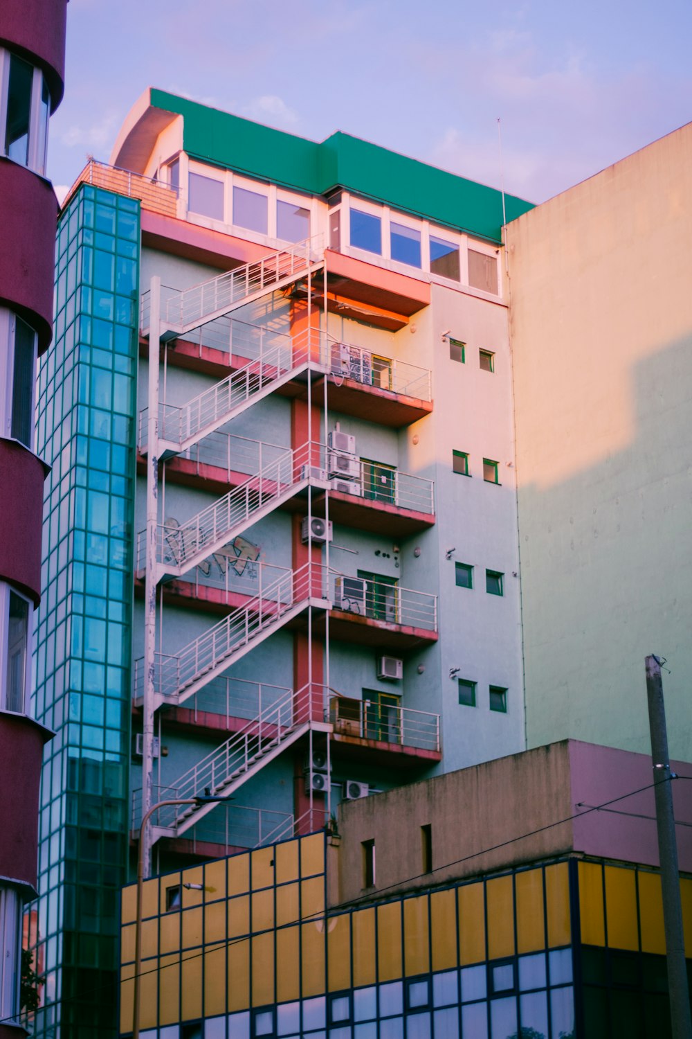 a multi - story building with balconies and a green roof