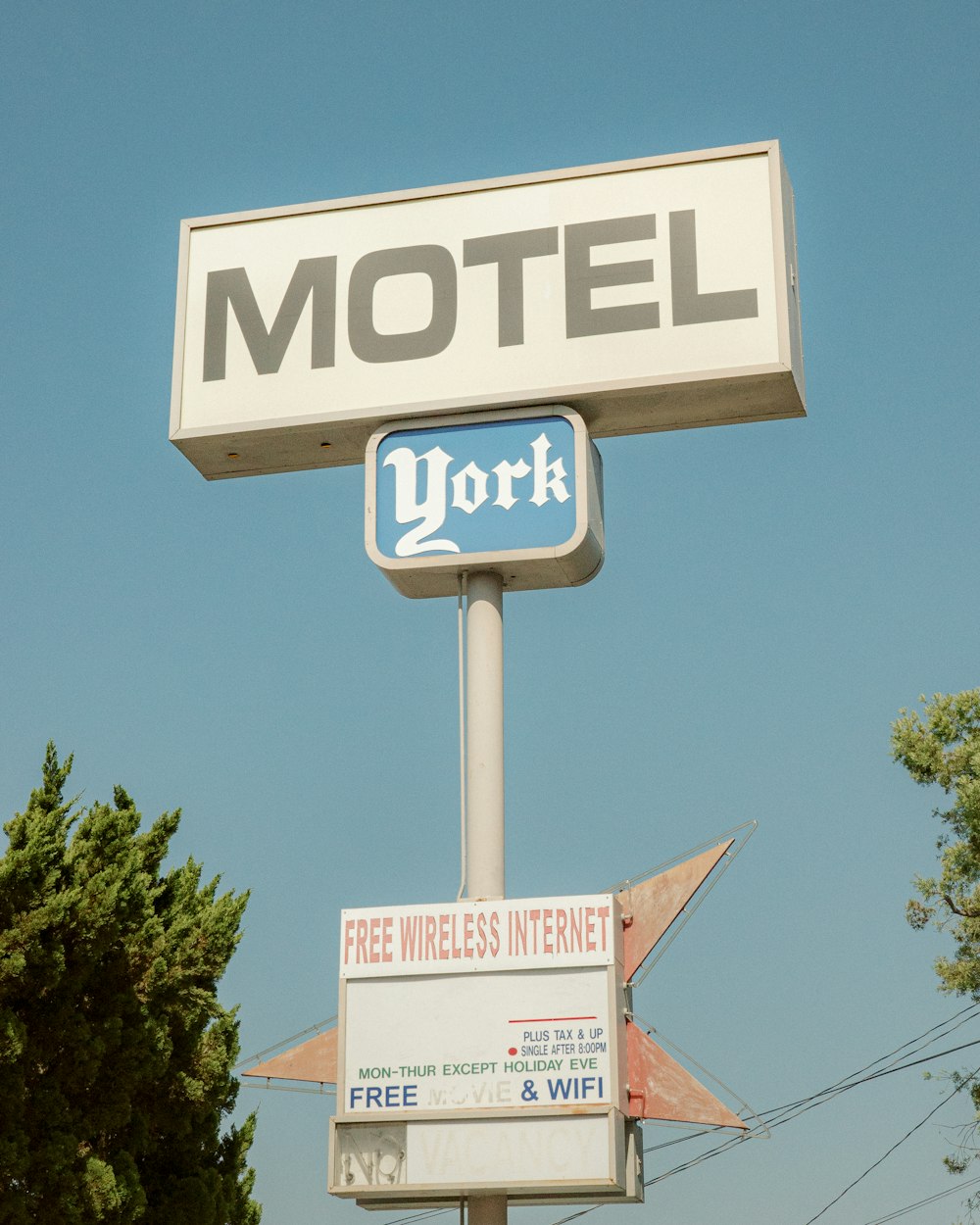 a motel sign with a free wireless internet sign below it