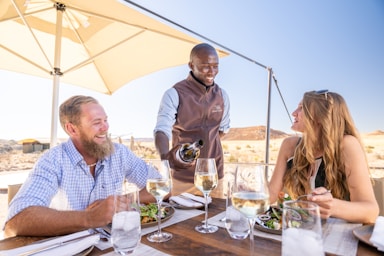 a group of people sitting at a table with plates of food