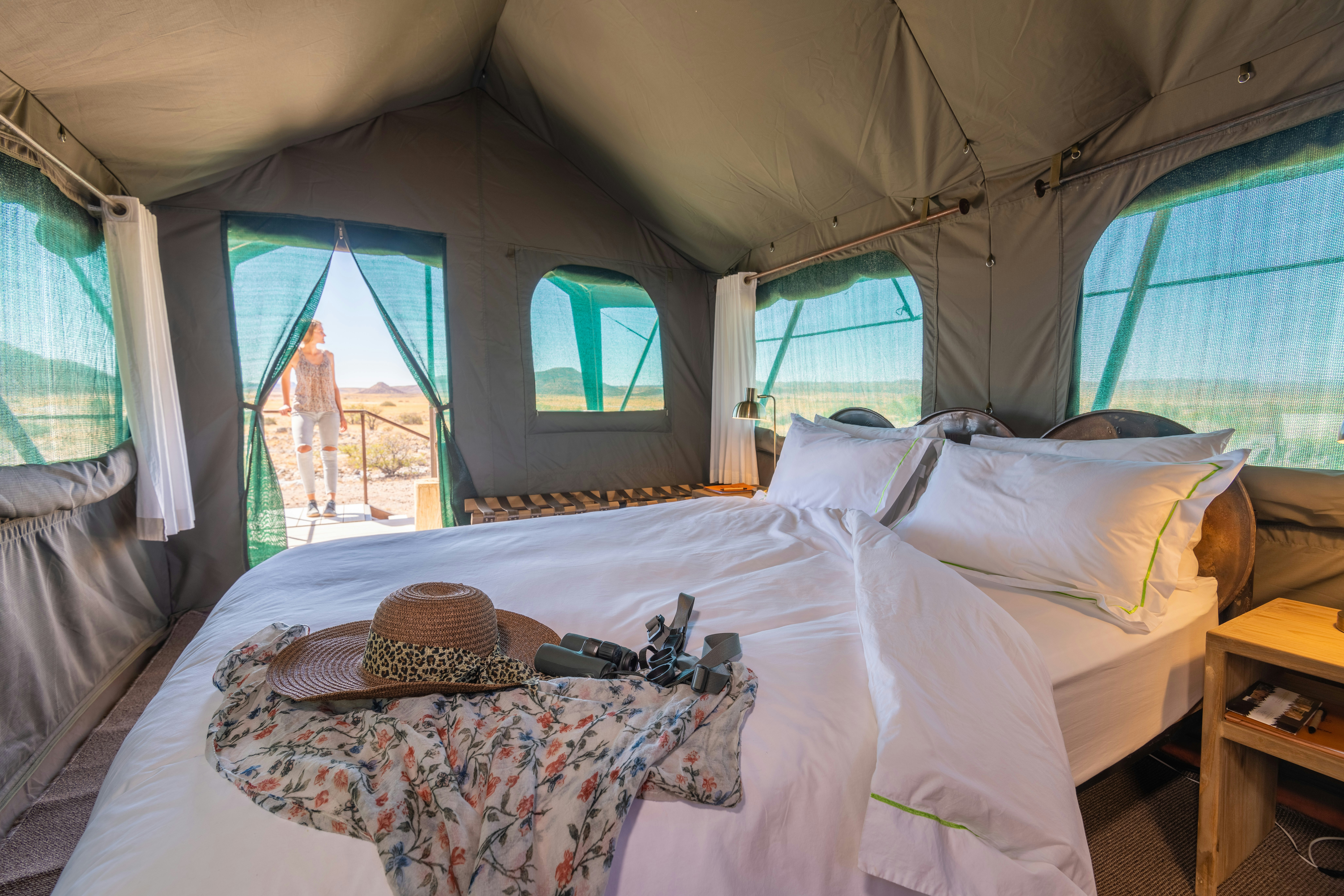 a bed in a tent with a hat on top of it