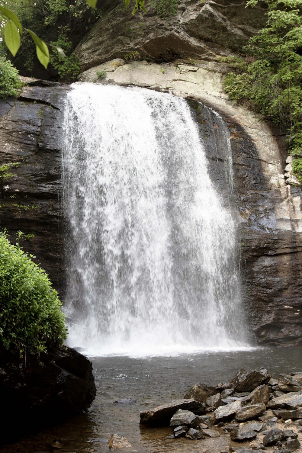 a waterfall with a man standing in front of it