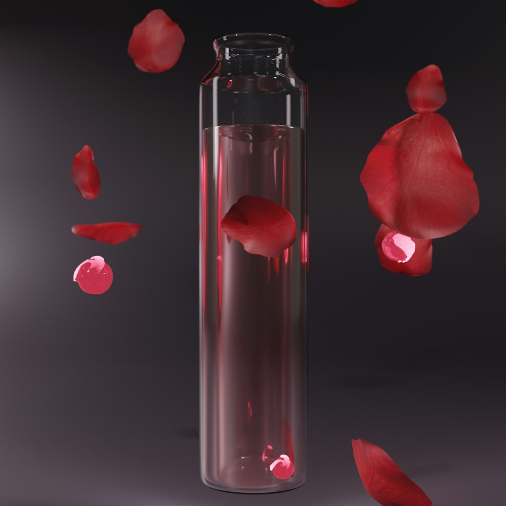 a glass vase filled with water and red petals