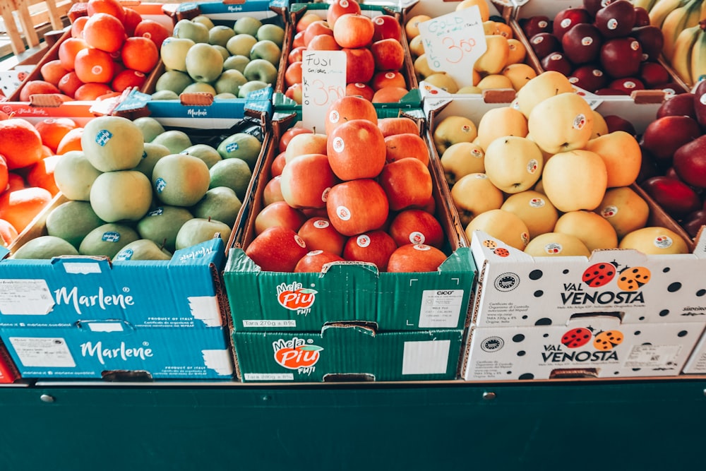 a fruit stand with apples, oranges, apples, and pears