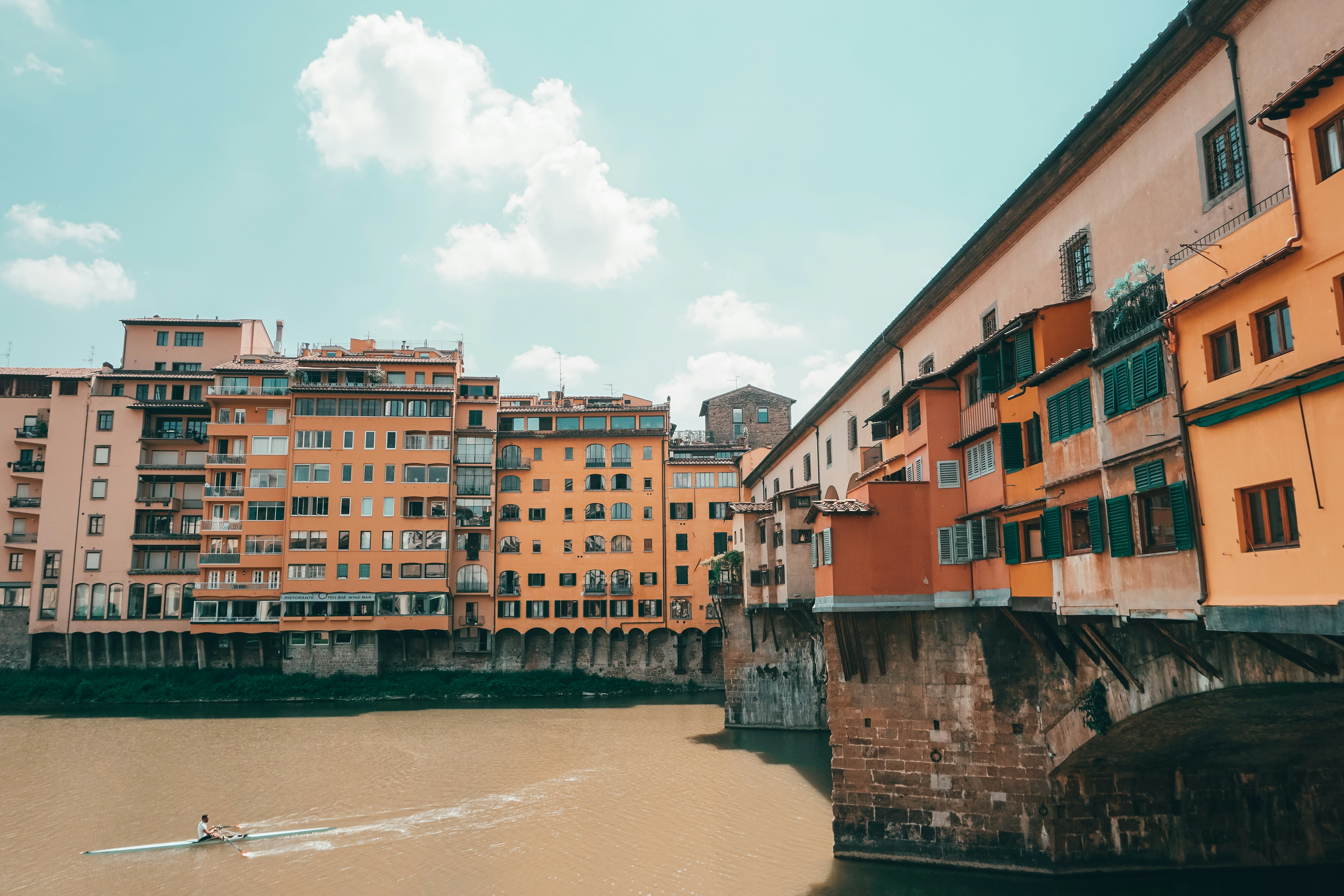 A person rowing a boat down a river in a city