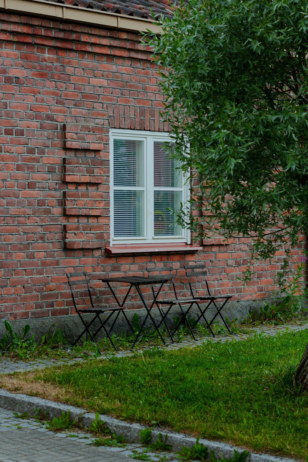 um edifício de tijolos com uma mesa e cadeiras à sua frente
