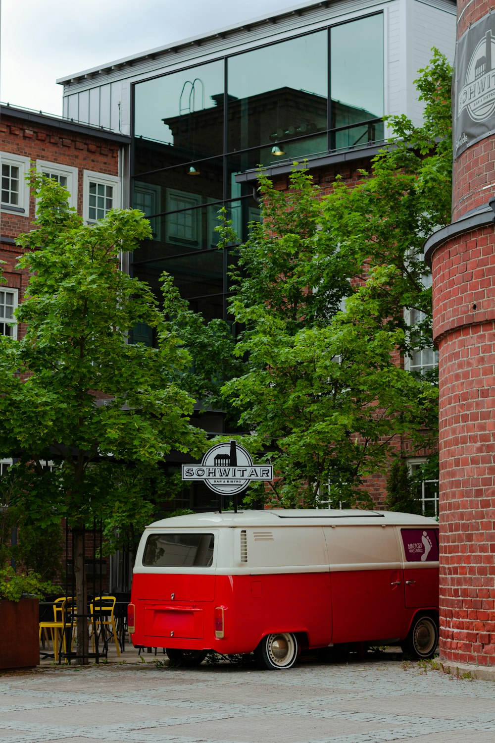 a red and white bus parked in front of a building