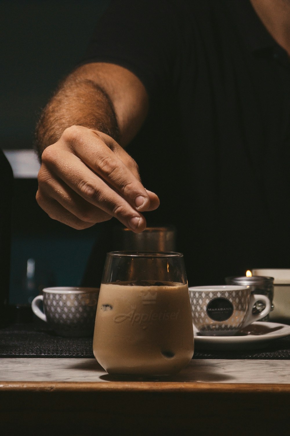 a person sitting at a table with a cup of coffee