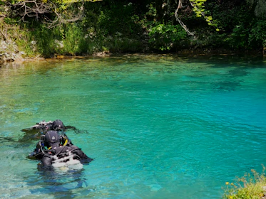 Group of divers practicing rescue techniques in calm water.