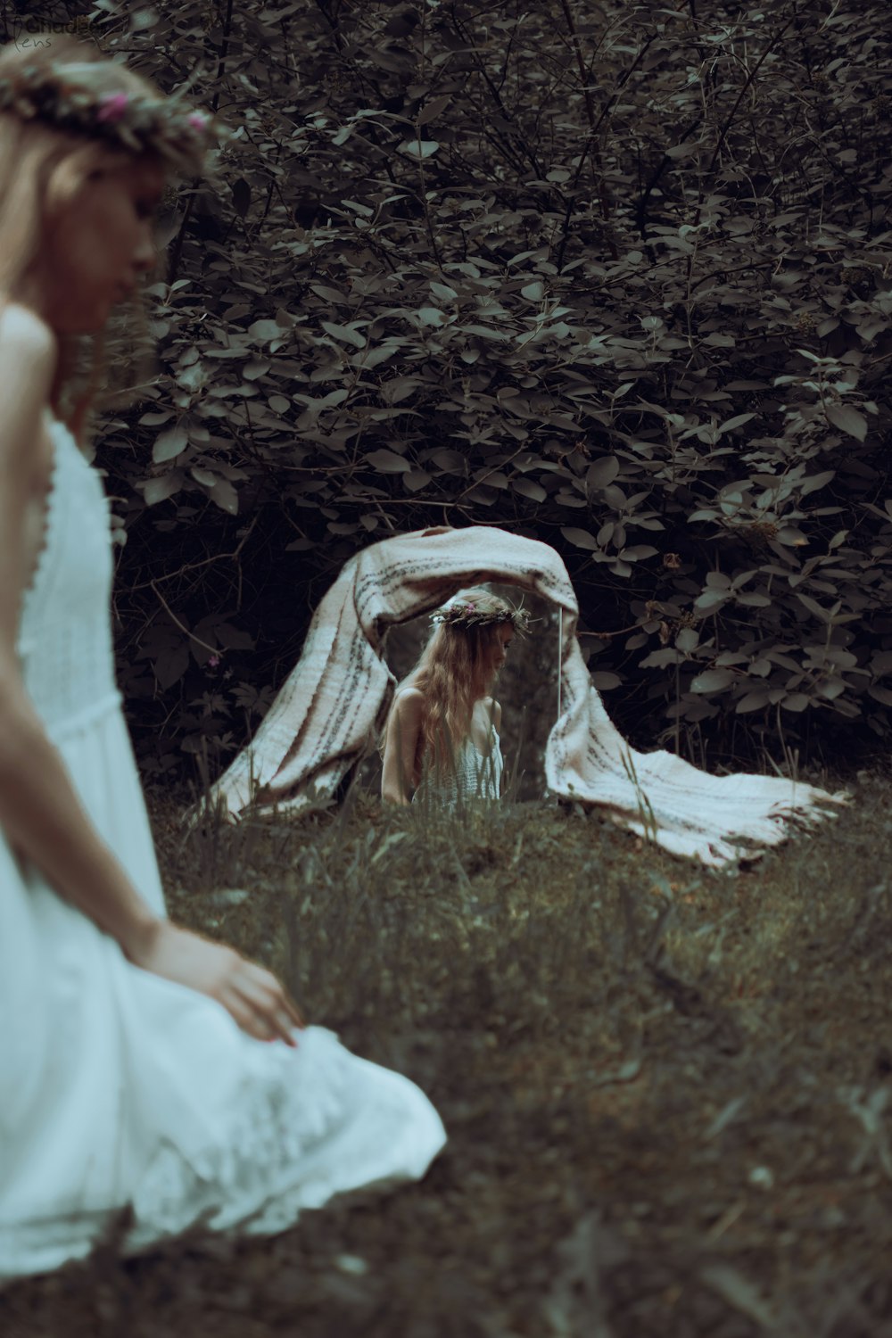 a woman in a white dress sitting in the grass