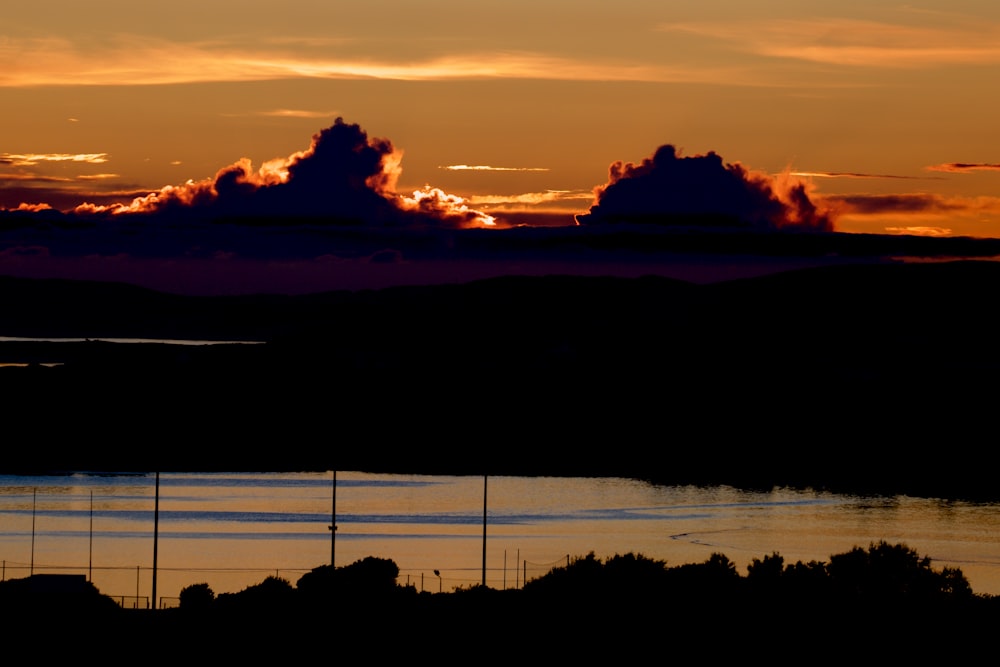 the sun is setting over a body of water