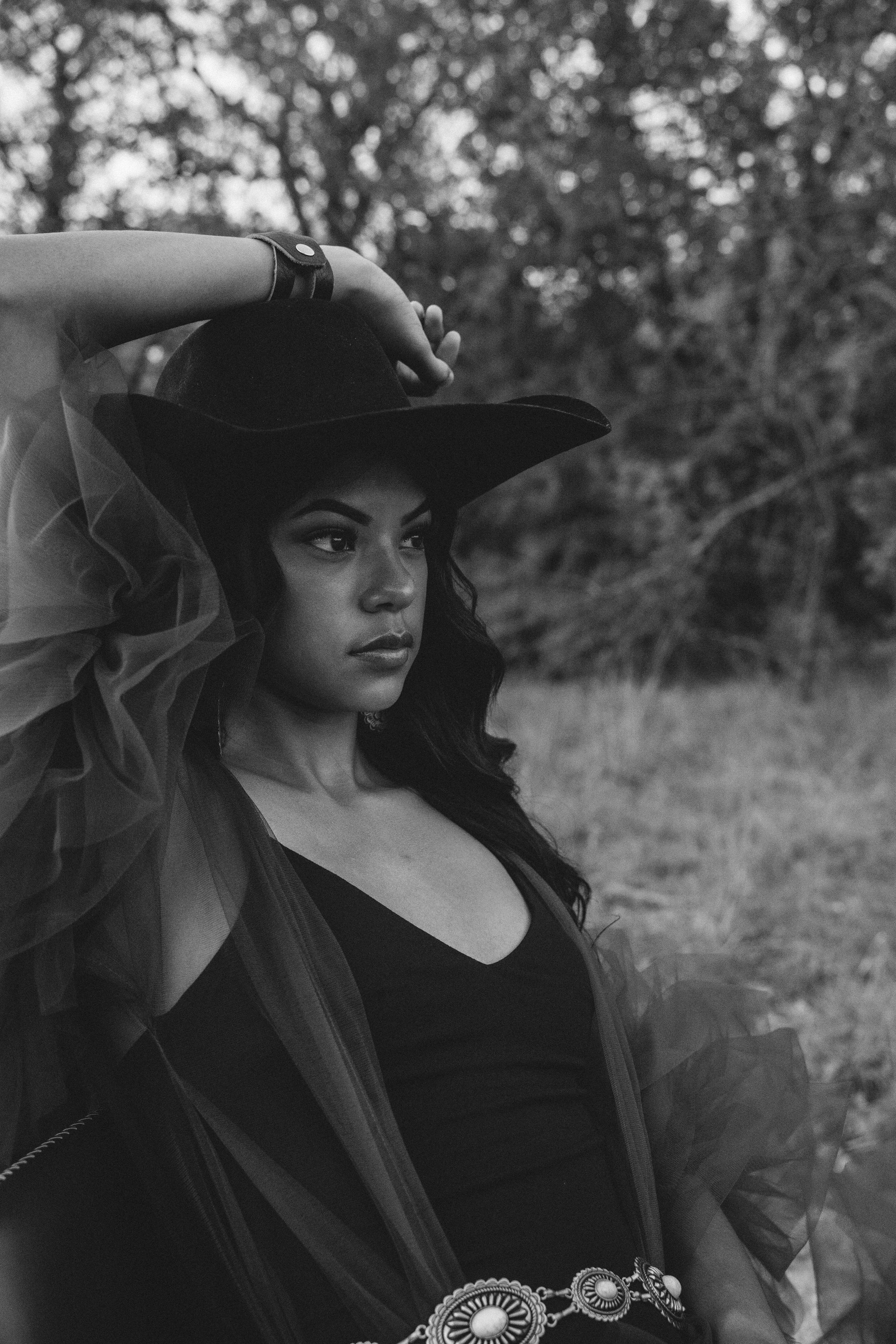 a black and white photo of a woman wearing a hat