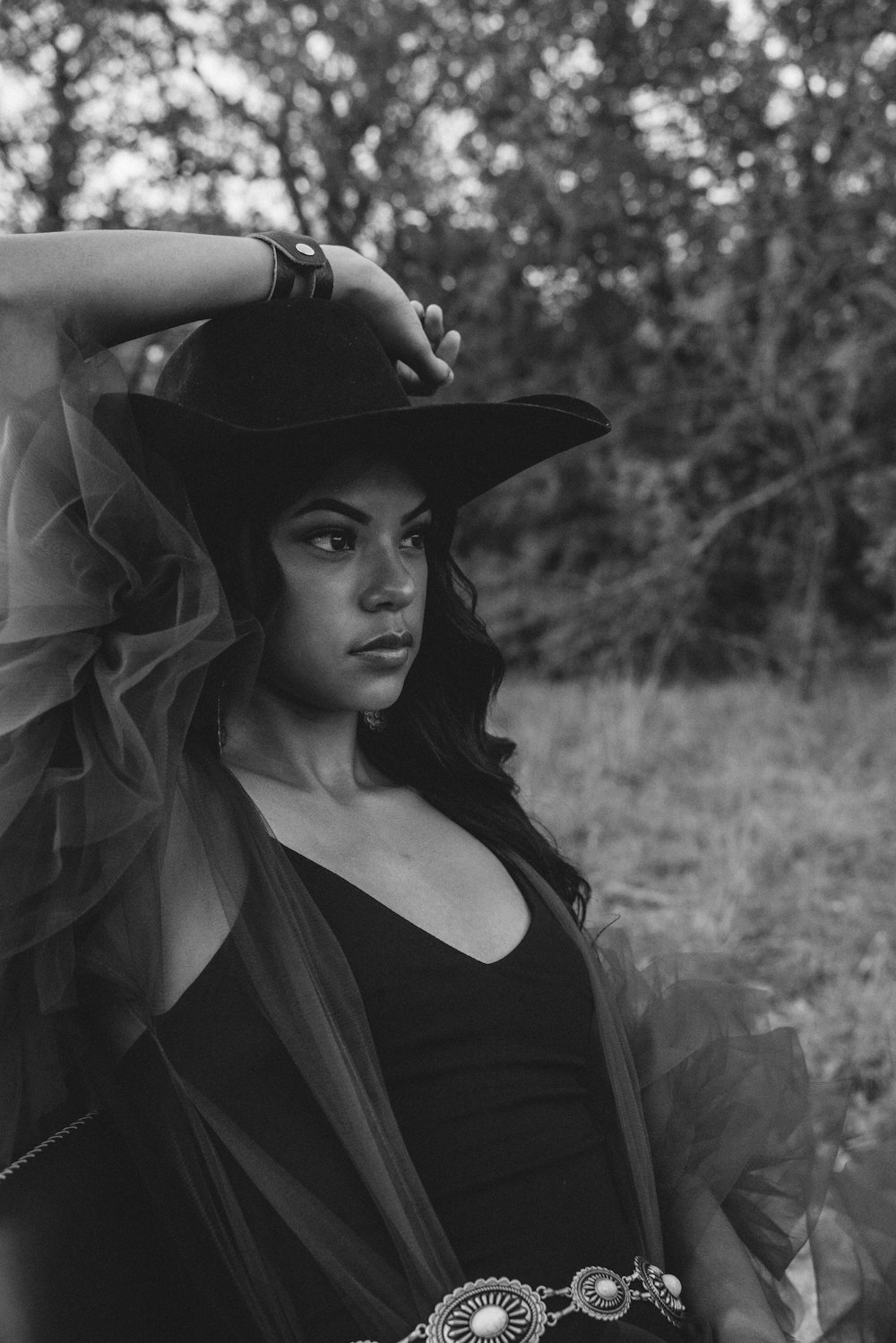 a black and white photo of a woman wearing a hat