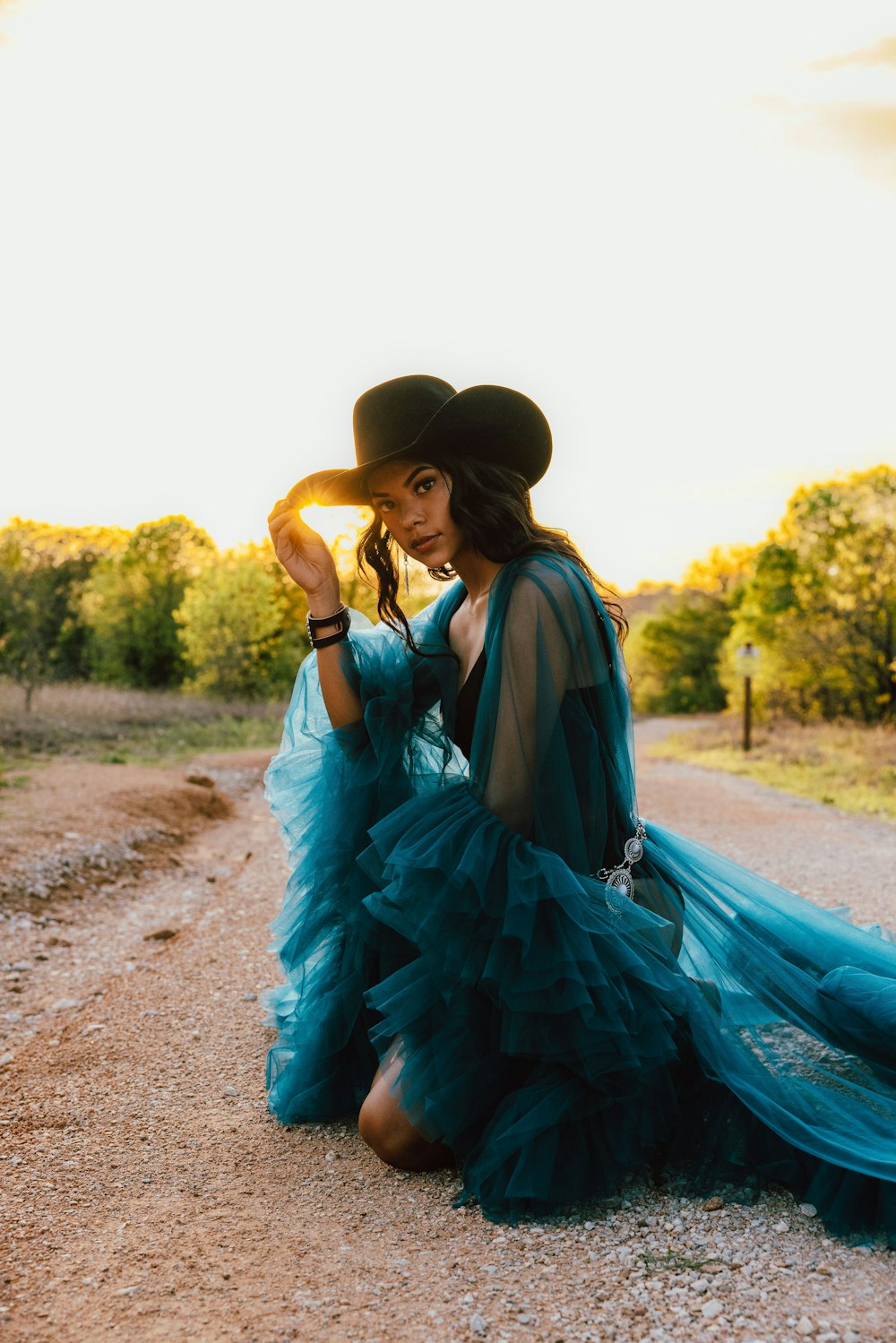 a woman in a blue dress and a cowboy hat
