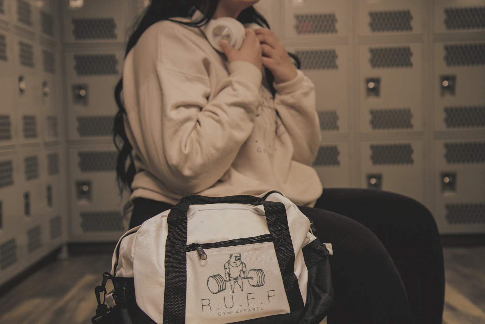 Woman with a duffle bag in a modern athletic locker room
