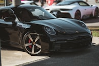 A sleek car being polished to a glossy finish outdoors.