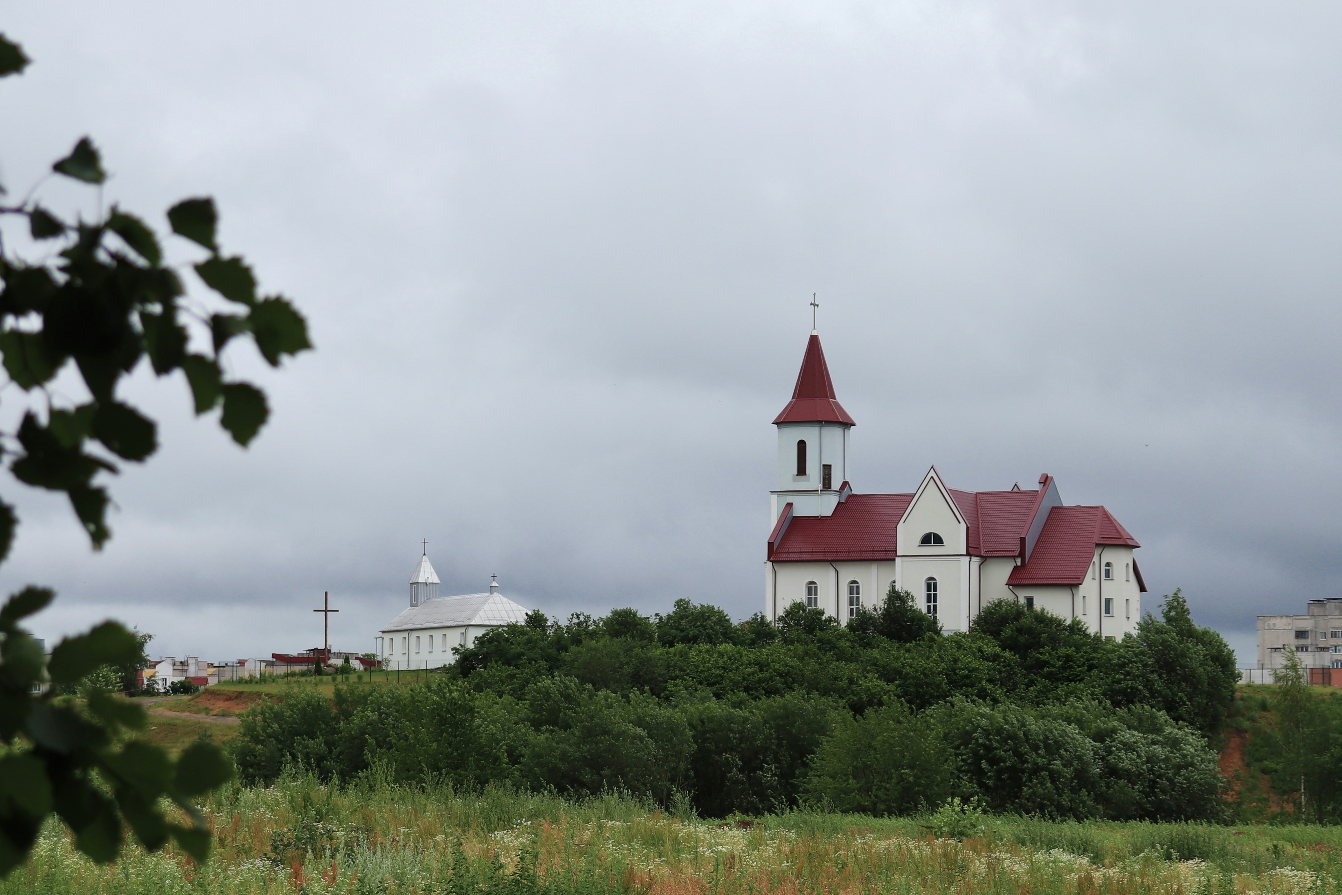Una iglesia blanca con un techo rojo en una colina