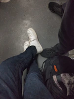 Bright sneakers resting beside a casual denim jacket on a city sidewalk.