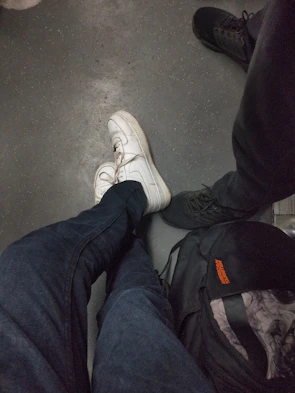 Bright sneakers resting beside a casual denim jacket on a city sidewalk.