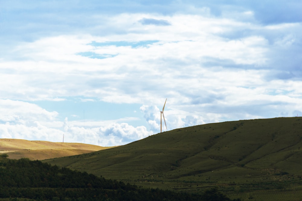 a hill with a wind turbine in the distance