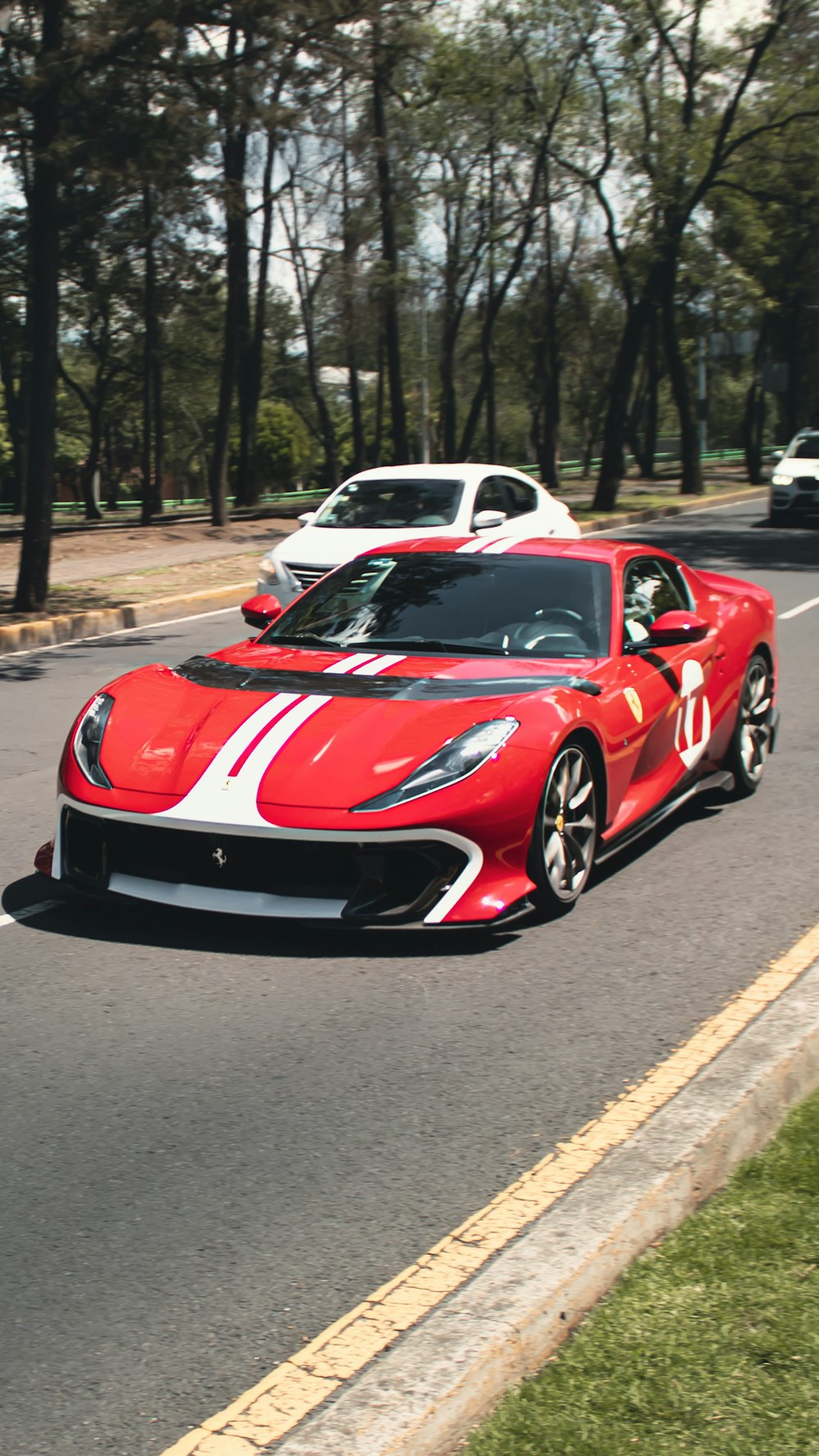 a red sports car driving down the road