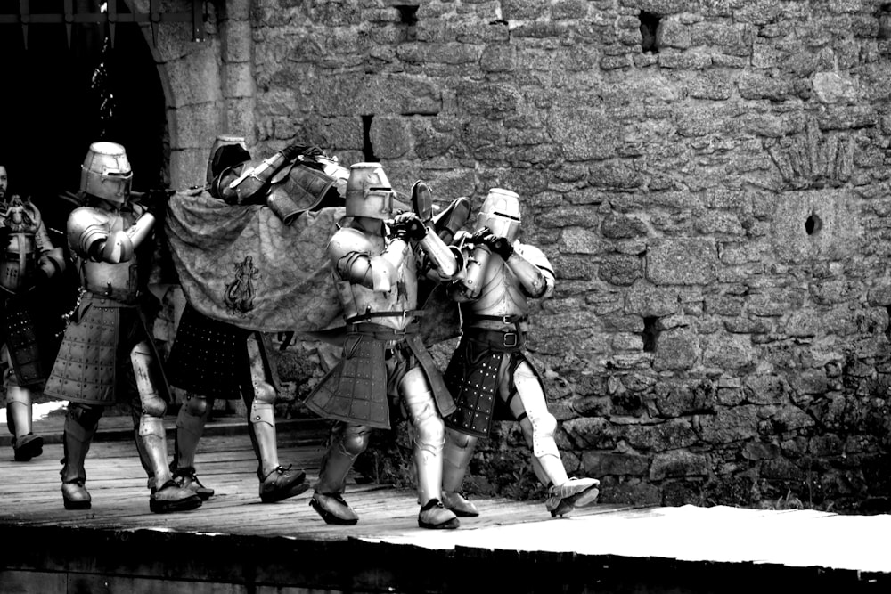 a black and white photo of men in medieval costumes