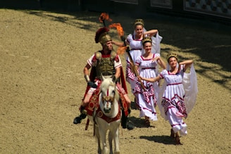 Roman soldiers leading captured enemies as slaves through a rugged landscape.