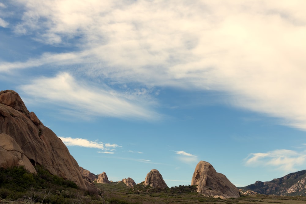 a large rock formation in the middle of a field