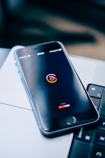 a cell phone sitting on top of a laptop computer