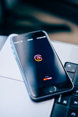 a cell phone sitting on top of a laptop computer