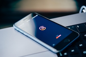 a cell phone sitting on top of a laptop computer