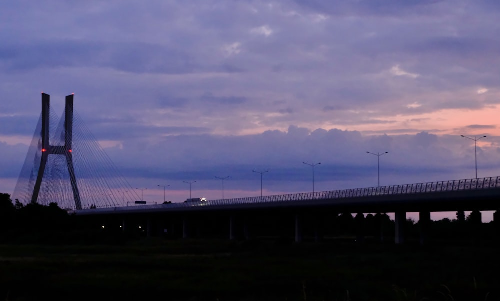 a bridge that is over some water with a sky background