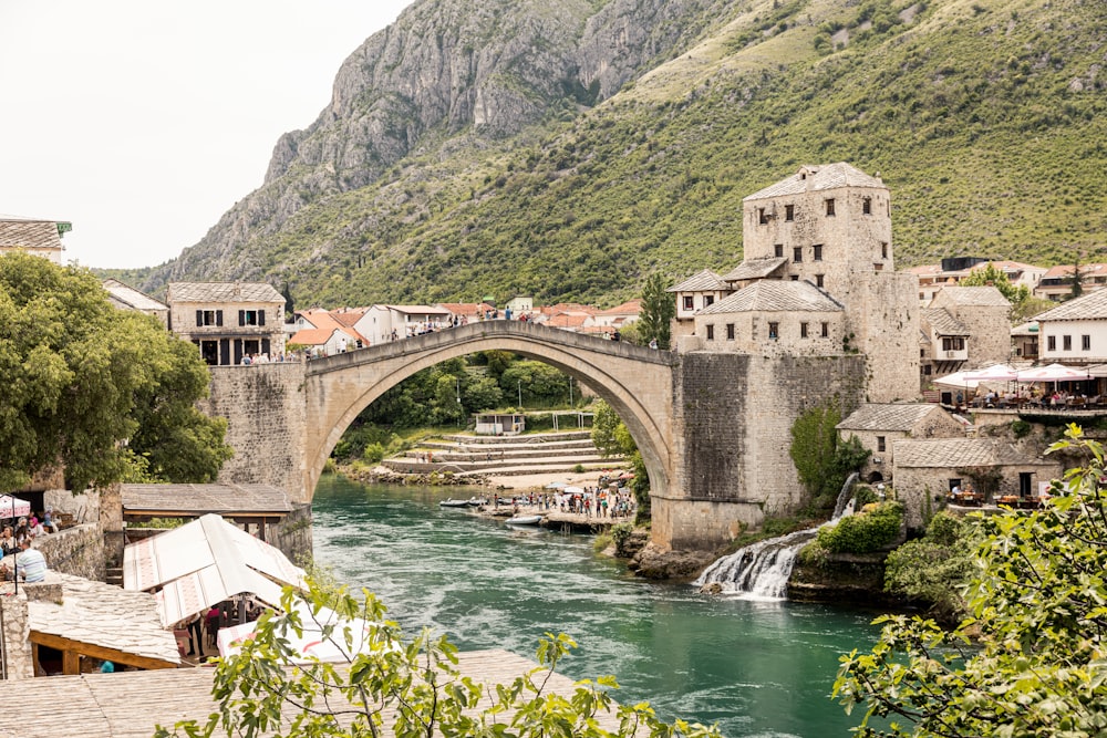 a bridge over a river with a waterfall in front of it