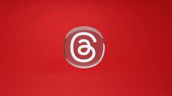 A stylized letter 'a' is encased in a circular, glossy emblem set against a vibrant red background. The design is minimalistic and centered, with a smooth, reflective surface giving it a polished appearance.