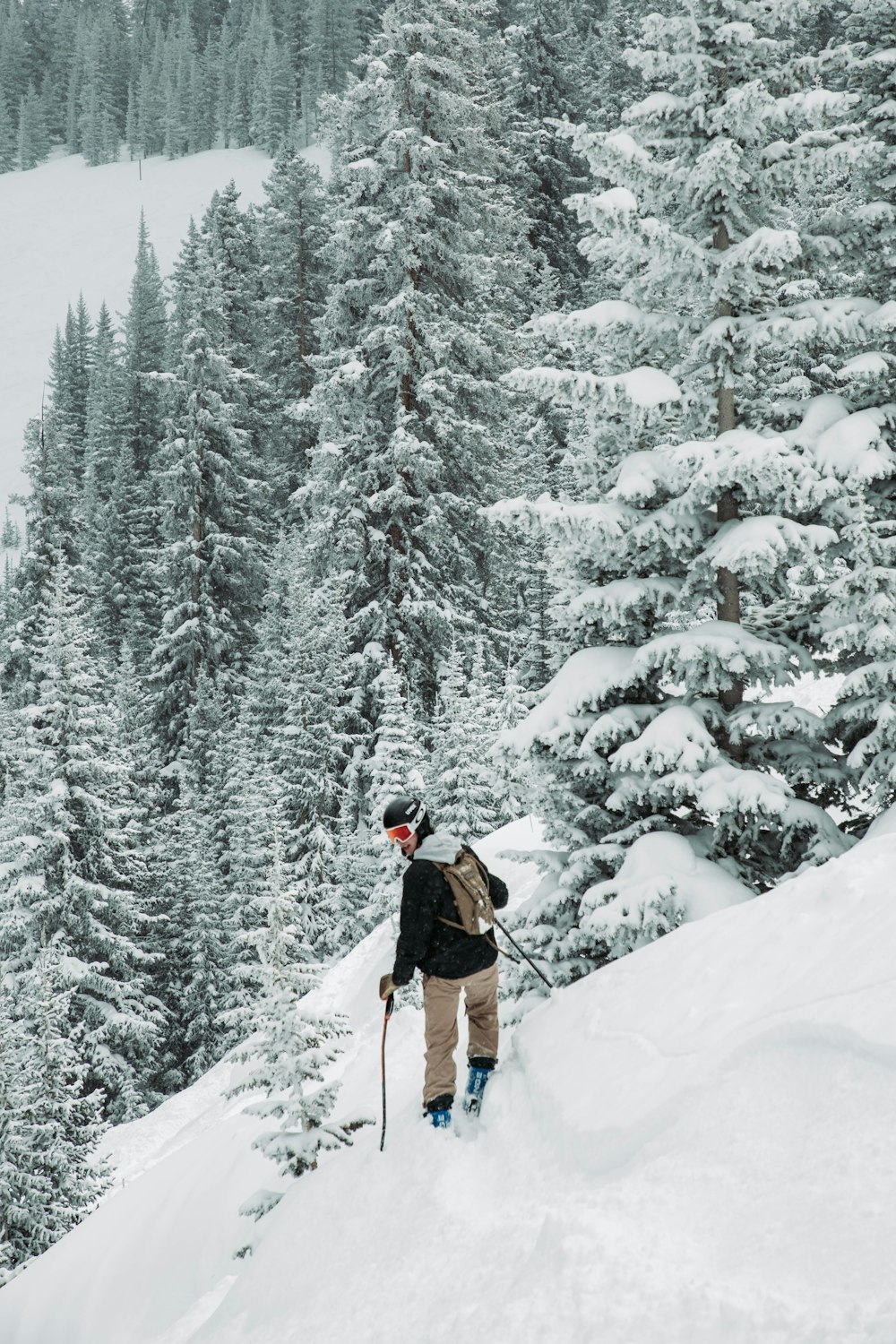 a person standing on top of a snow covered slope